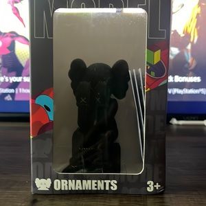 Black kaws doll sitting